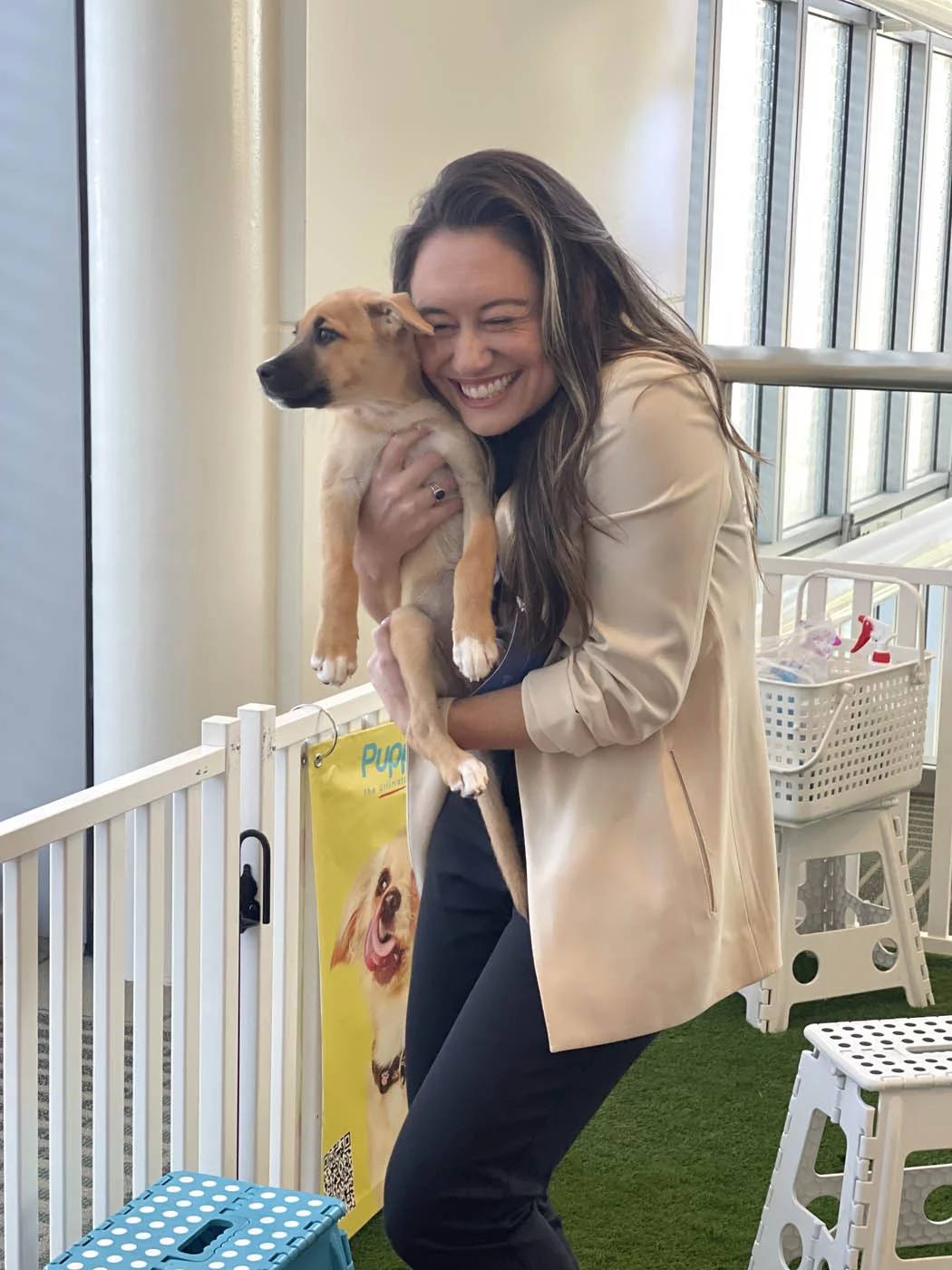 A woman holding a puppy and experiencing so much joy thanks to puppy love™.