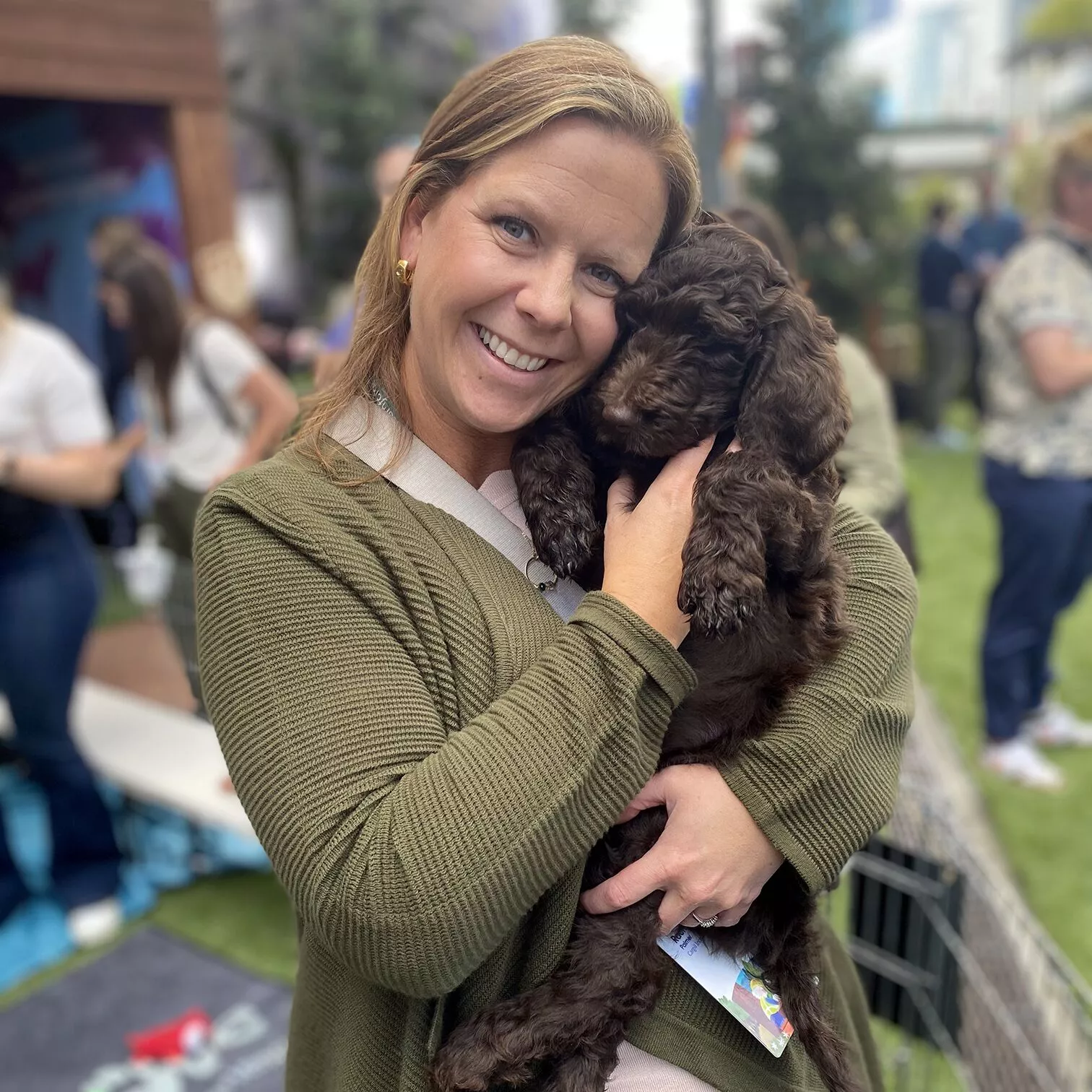 An adorable puppy from puppy love™ and an expo attendee smiling big for the camera!
