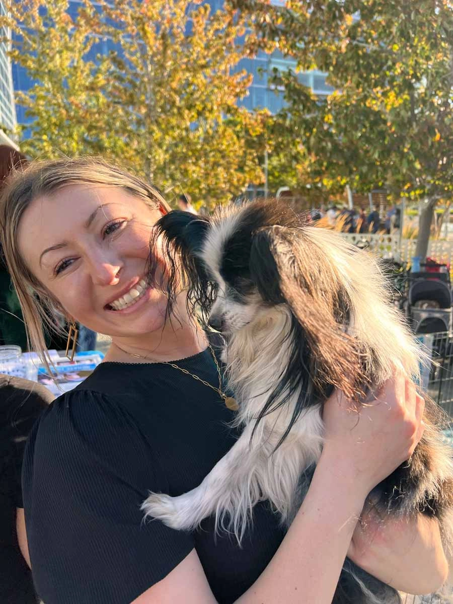 Woman at a google event holding a puppy from puppy love™'s puppy experience.