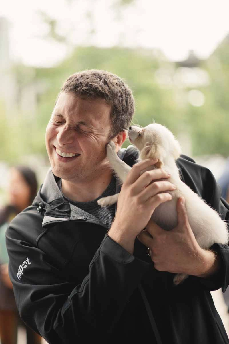 An employee enjoying puppy love™'s puppy experience as part of incorporating work wellness program ideas.