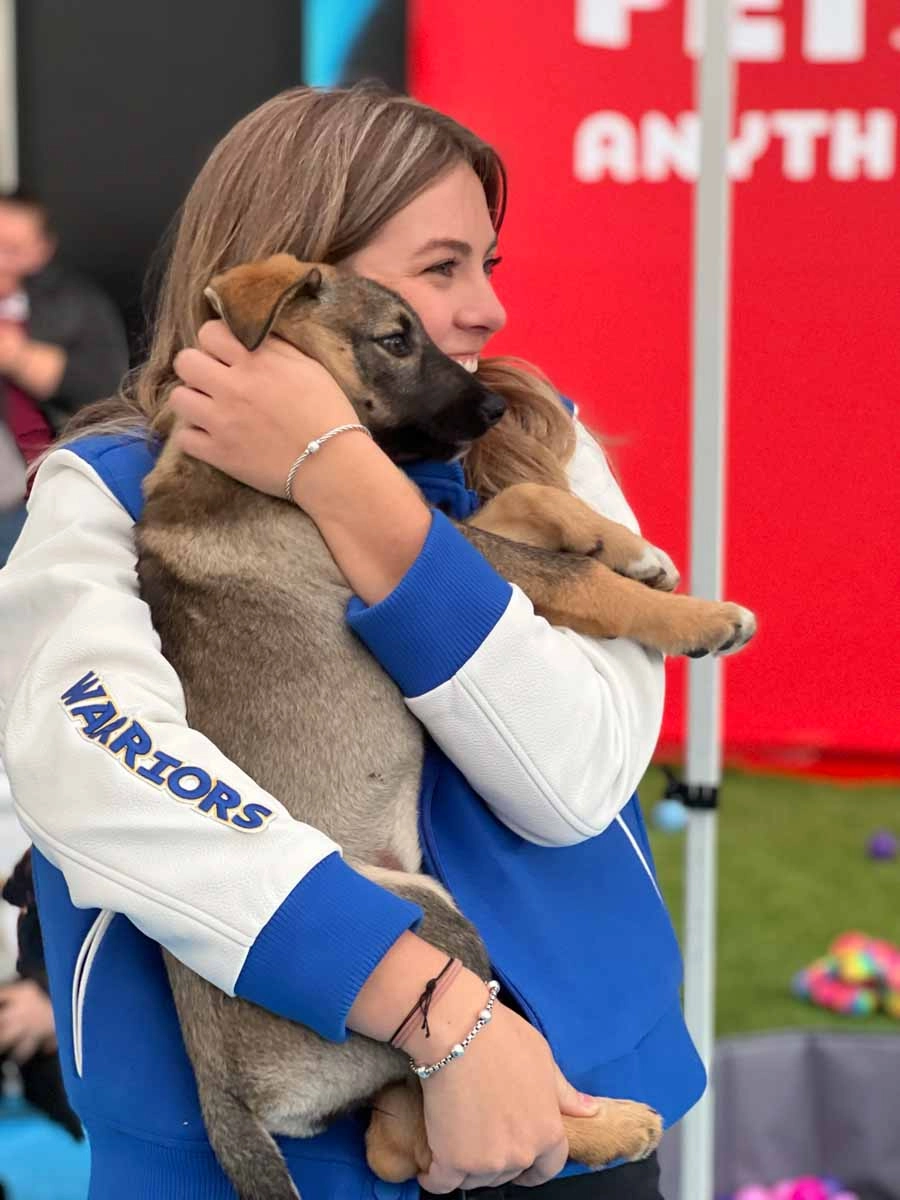 Smile as big as this person when you hold a puppy at a community sports and wellness center event.