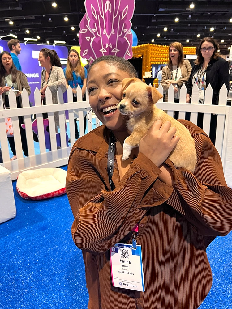 A Puppy Love™ employee with a puppy at a tradeshow booth event.